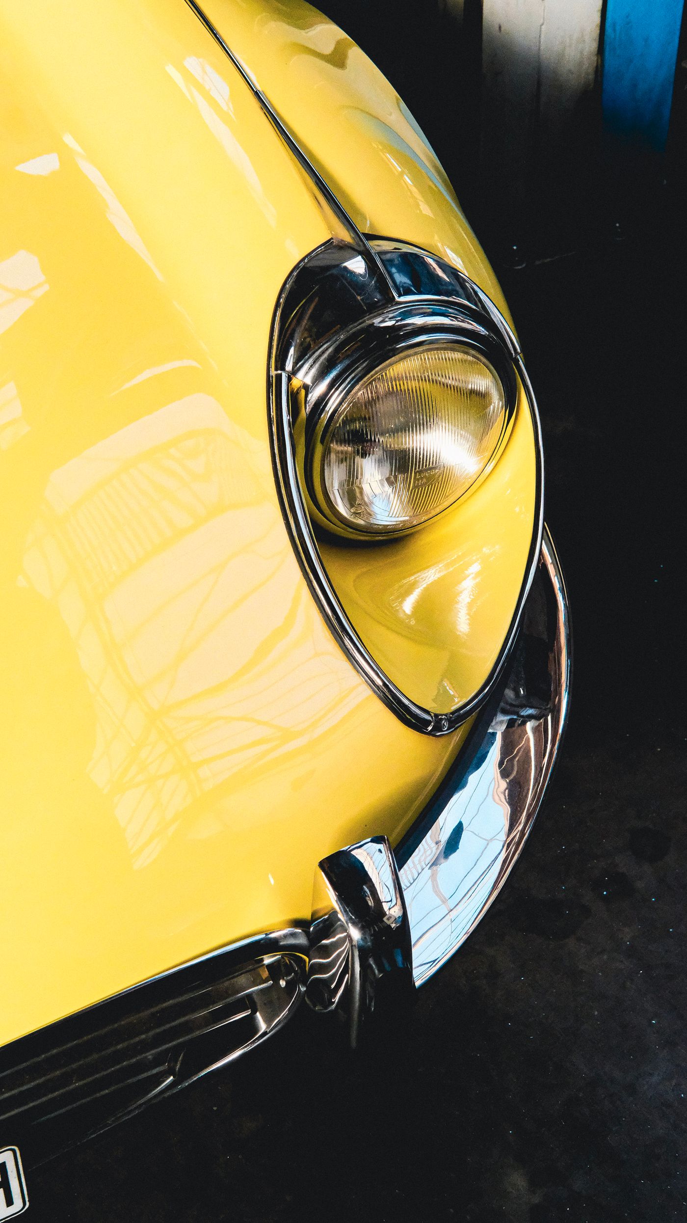 Farol cromado de um carro clássico amarelo
